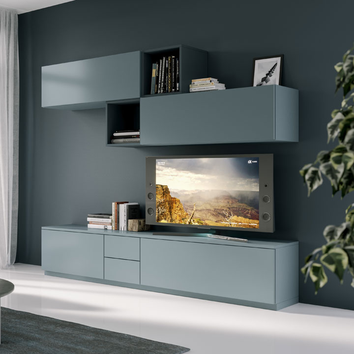 Soluzione d'arredo composta da mobili componibili per il soggiorno di colore azzurro polvere opaco, composta da mobile tv, elementi libreria con sportelli e aperti, cassettiera e pensili con sportelli. Finiture in colore pieno RAL. Soggiorno modulare Quattrolati di Benigni Mobili. Prospettiva laterale.